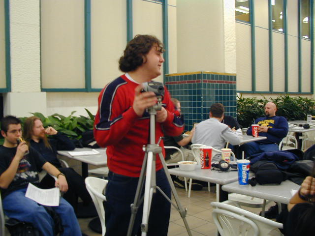 A setting up his tripod to take pictures of the speakers.